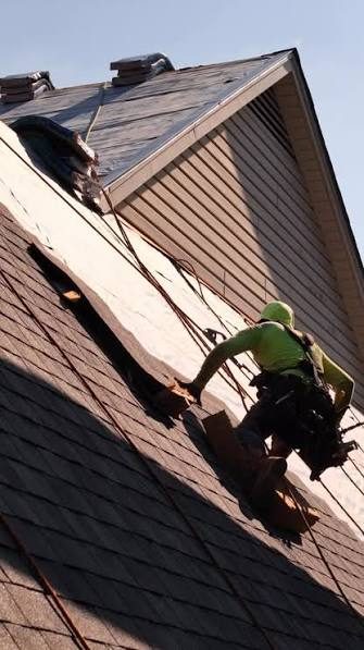 Roofer in a safety harness on a steep slope in Belleville, IL, roofed by John Beal Roofing
