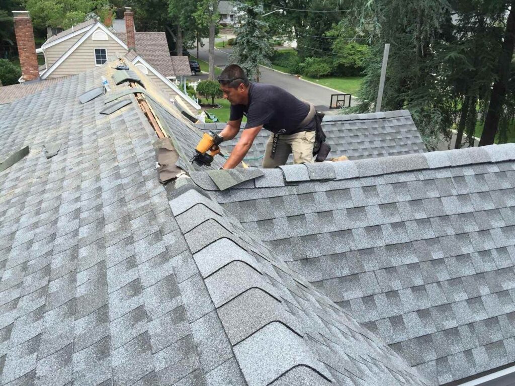 Ridge cap shingles going on at the end of a St. Louis roofing job